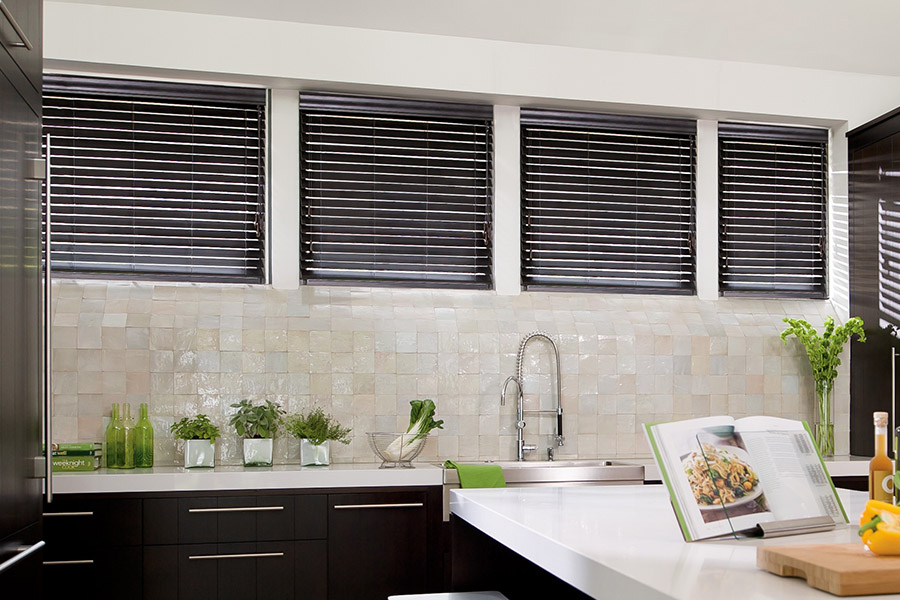 Choose custom Polywood faux wood blinds for your kitchen in Salt Lake City. Special shaped faux wood blinds in several windows above a sink.