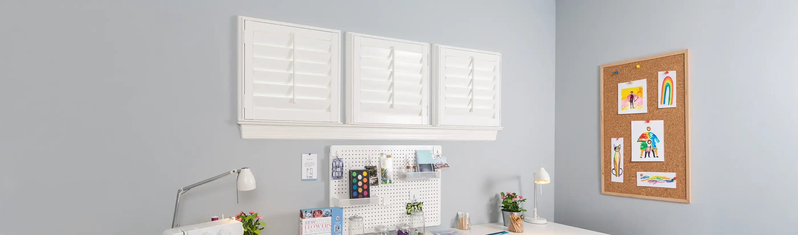white small square studio shutters above a desk and crafting area