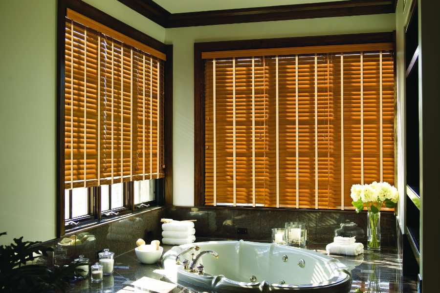 Premium quality blinds are always a stylish accent in your Salt Lake City home. Brown wood blinds on large windows in a green bathroom