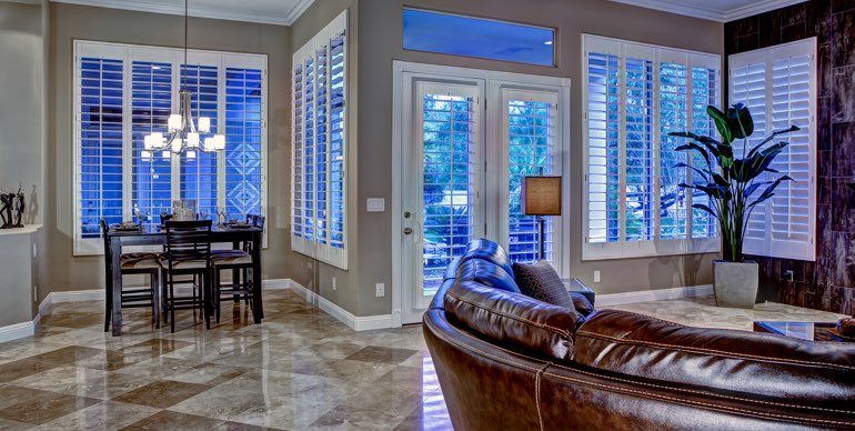 Photo Courtesy of Room Resolutions Salt Lake City great room with classic shutters and tile floor.