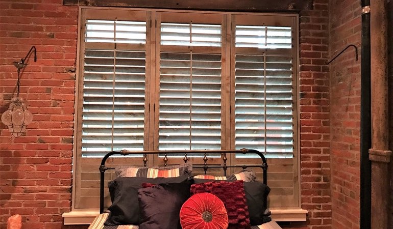 Reclaimed wood shutters add a natural feel to your minimalist spaces. Reclaimed wood shutters surrounded by brick wall.