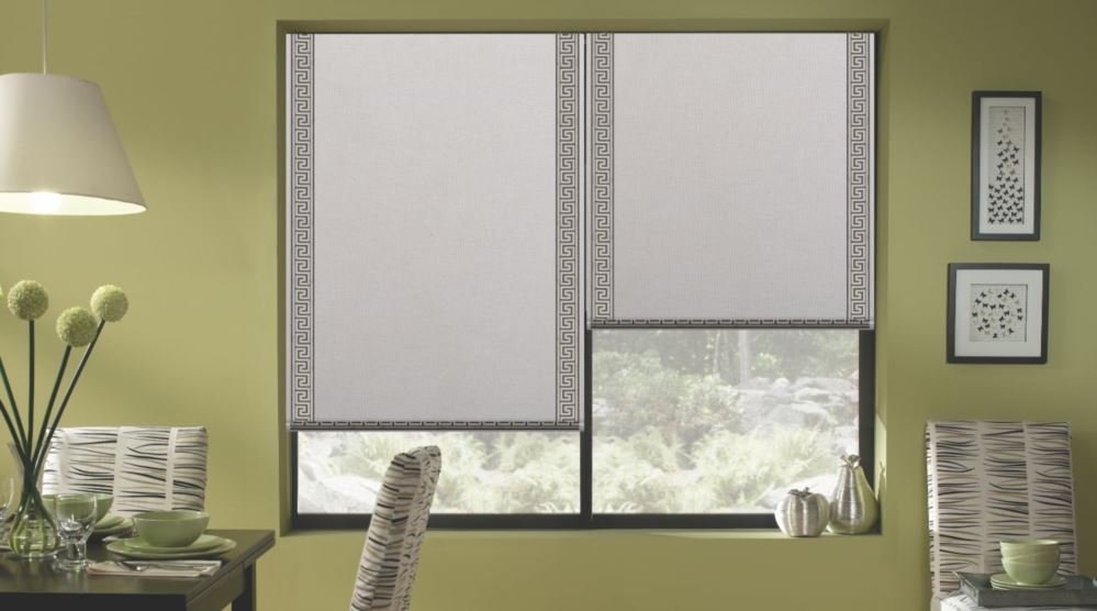 Motorized shades can be automated and controlled via a mobile app or using voice commands. Motorized roller shades in a dining room.