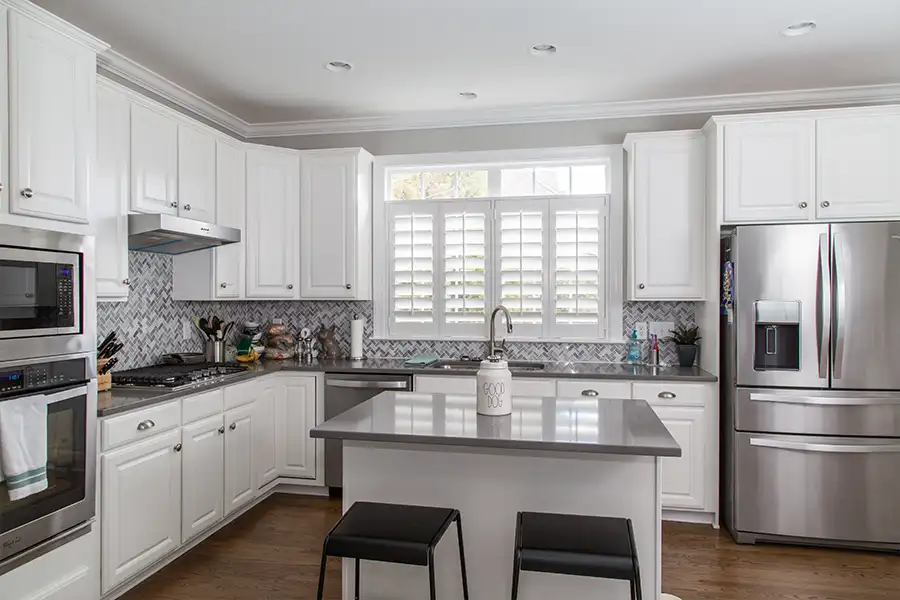 A modern kitchen with matching stainless steel fridge, dishwasher, and double oven