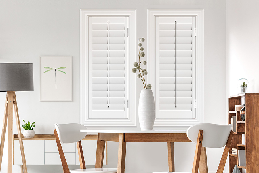 Sunburst's selection of stylish window treatments for designers in Salt Lake City makes it easy to find the perfect ones for every design job.  White Polywood shutters on two windows in a modern Scandinavian-style room