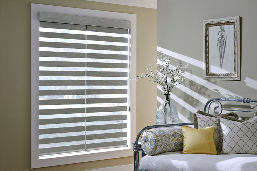Find Functional and stylish window blinds for Salt Lake City homes at Sunburst. Gray blinds on a large window next to a couch.